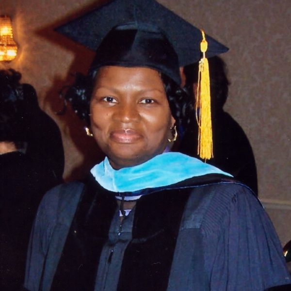 Picture of Dr. Betty Howard in a navy color doctorial graduation gown.