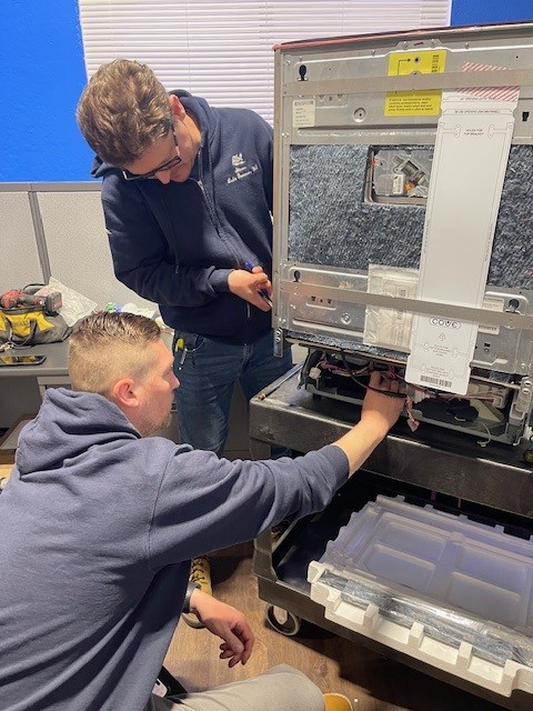 An Abt apprentice being taught how to operate and maintan a machine.